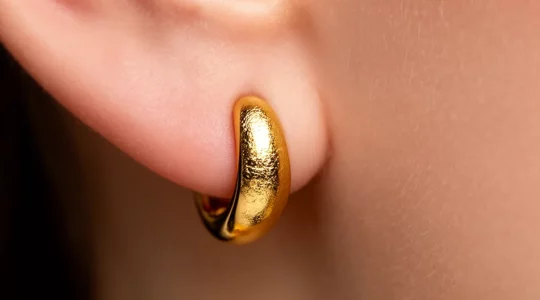 Detailaufnahme von goldenen Ohrringen mit Fokus auf Hautverträglichkeit und Metalllegierungen
