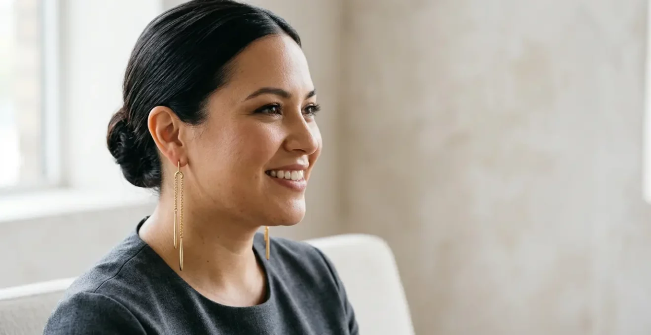 Stilvolle Frau mit rundem Gesicht trägt längliche goldene Ohrhänger