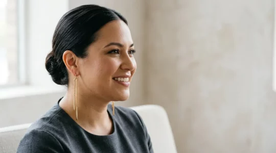 Stilvolle Frau mit rundem Gesicht trägt längliche goldene Ohrhänger